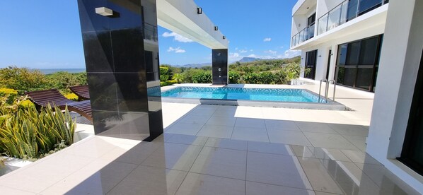 A modern outdoor pool area with a clear view of the mountains.