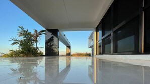 Ein modernes Gebäude mit spiegelndem Boden und großen Fenstern.