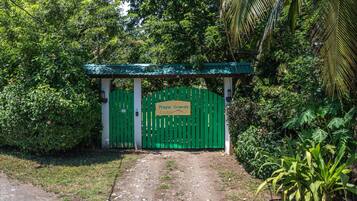 A green gate with a sign reading "Playa Grande Lodge".