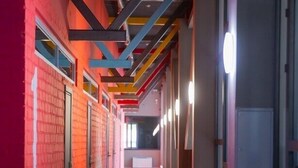 A corridor with red brick walls, metal beams, and a tiled floor. - City Hostel (Shymkent)