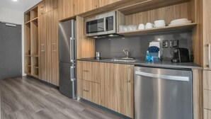 Una cucina moderna con mobili in legno, elettrodomestici in acciaio inossidabile e un forno a microonde integrato.
