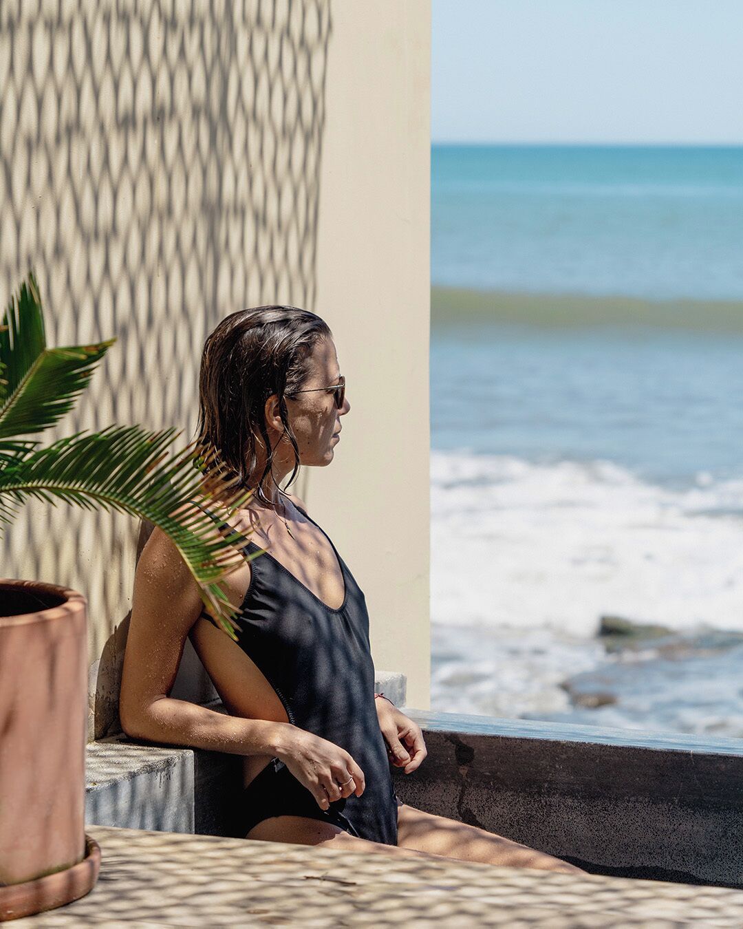 A person sitting on a balcony overlooking the ocean.