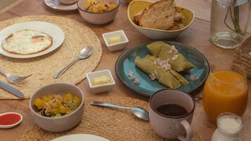 A breakfast table with various dishes, including eggs, toast, and fruit.