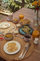A breakfast table with various dishes, including eggs, toast, and fruit.