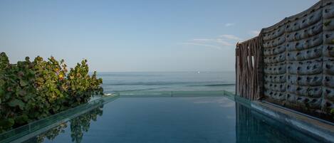 Una piscina infinita con vista despejada al océano.