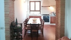 Un espace repas agrémenté d’une arche en briques qui mène à la cuisine.