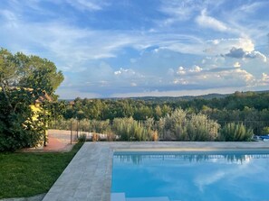 Une piscine offrant une vue dégagée sur le paysage environnant, notamment sur les arbres et les collines au loin.