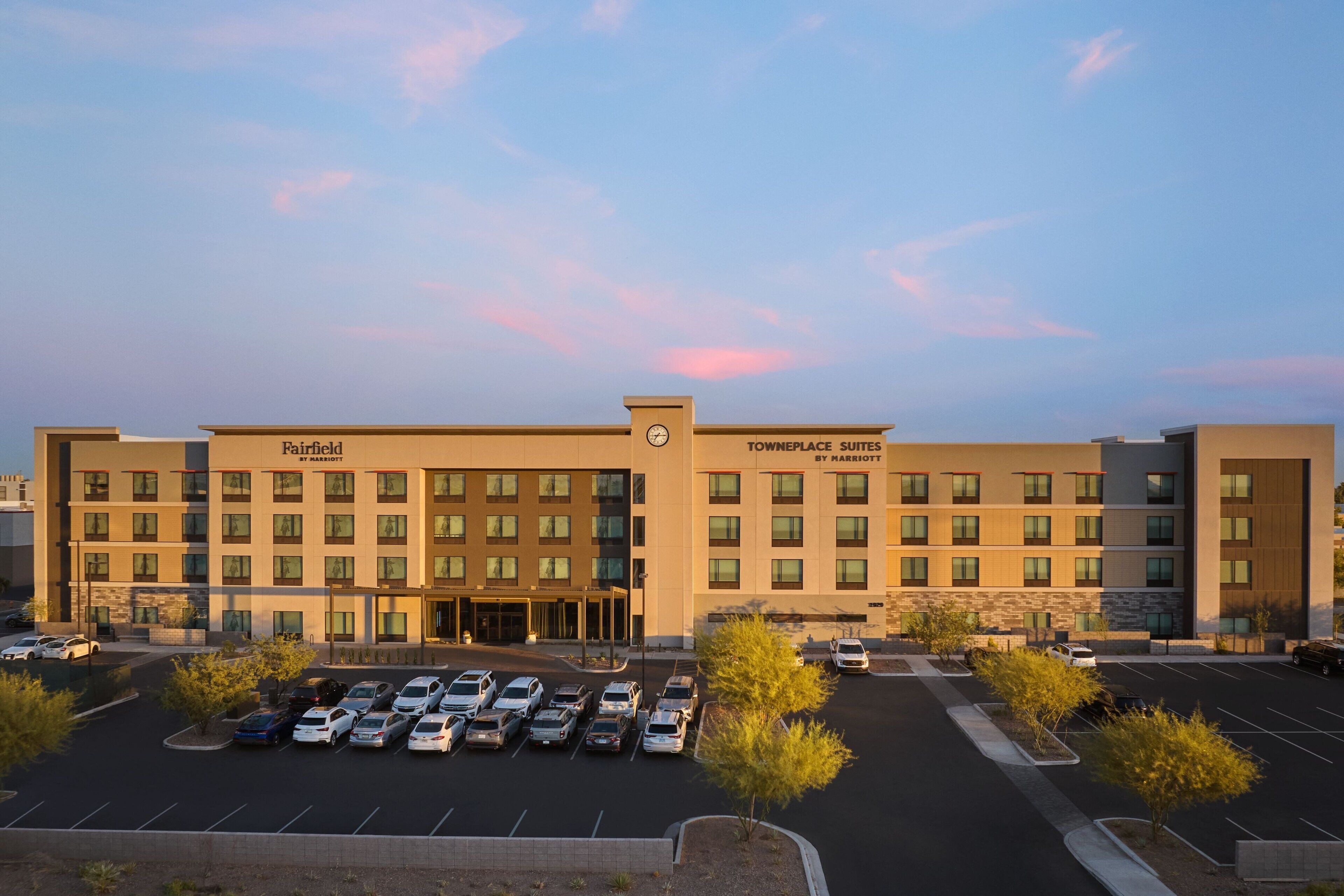 A hotel with a parking lot and a building labeled "Fairfield Townplace Suites by Marriott."