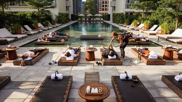 Relax by the serene pool surrounded by lush greenery and enjoy the tranquil atmosphere.