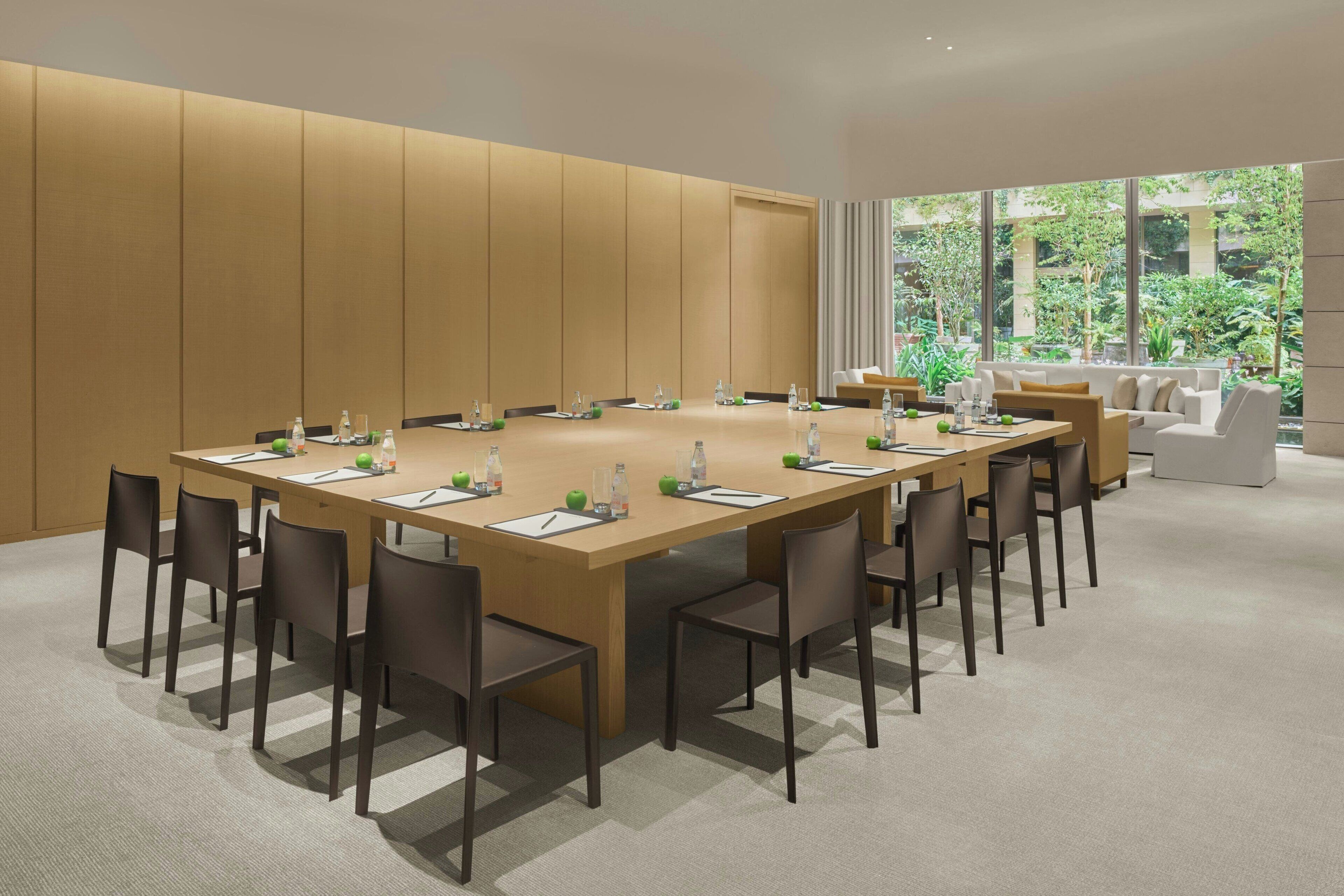 A conference room with a long table, chairs, and a sofa.