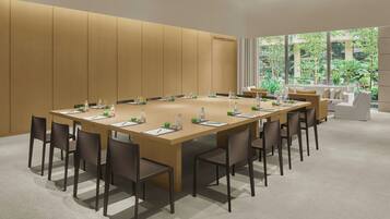 A conference room with a long table, chairs, and a sofa.