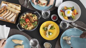 A dining table with various dishes, including a salad, pasta, and bread.