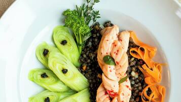 A plate with sliced fennel, salmon, lentils, and carrot ribbons.