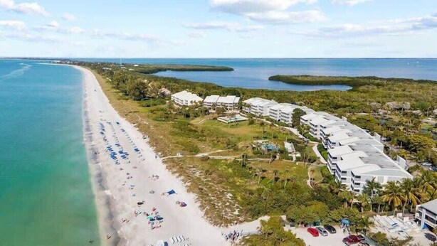 Un hôtel situé sur la côte, avec accès direct à la plage, composé de plusieurs bâtiments et offrant une vue dégagée sur l’océan.