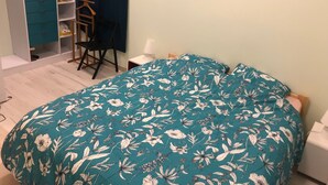 Ein Schlafzimmer mit Bett, Schreibtisch und Kleiderschrank.