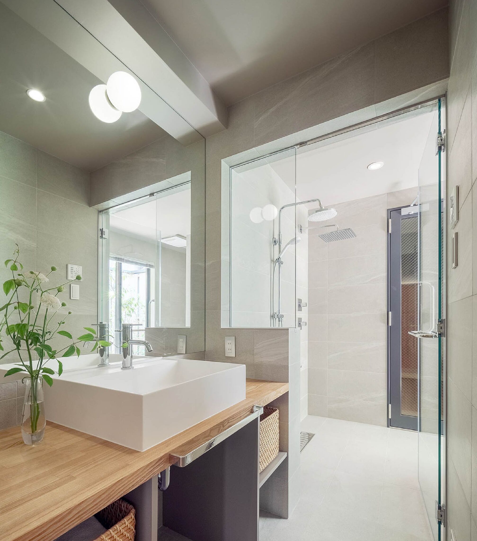 Une salle de bain moderne avec un grand lavabo blanc, une douche en verre et un meuble-lavabo en bois.
