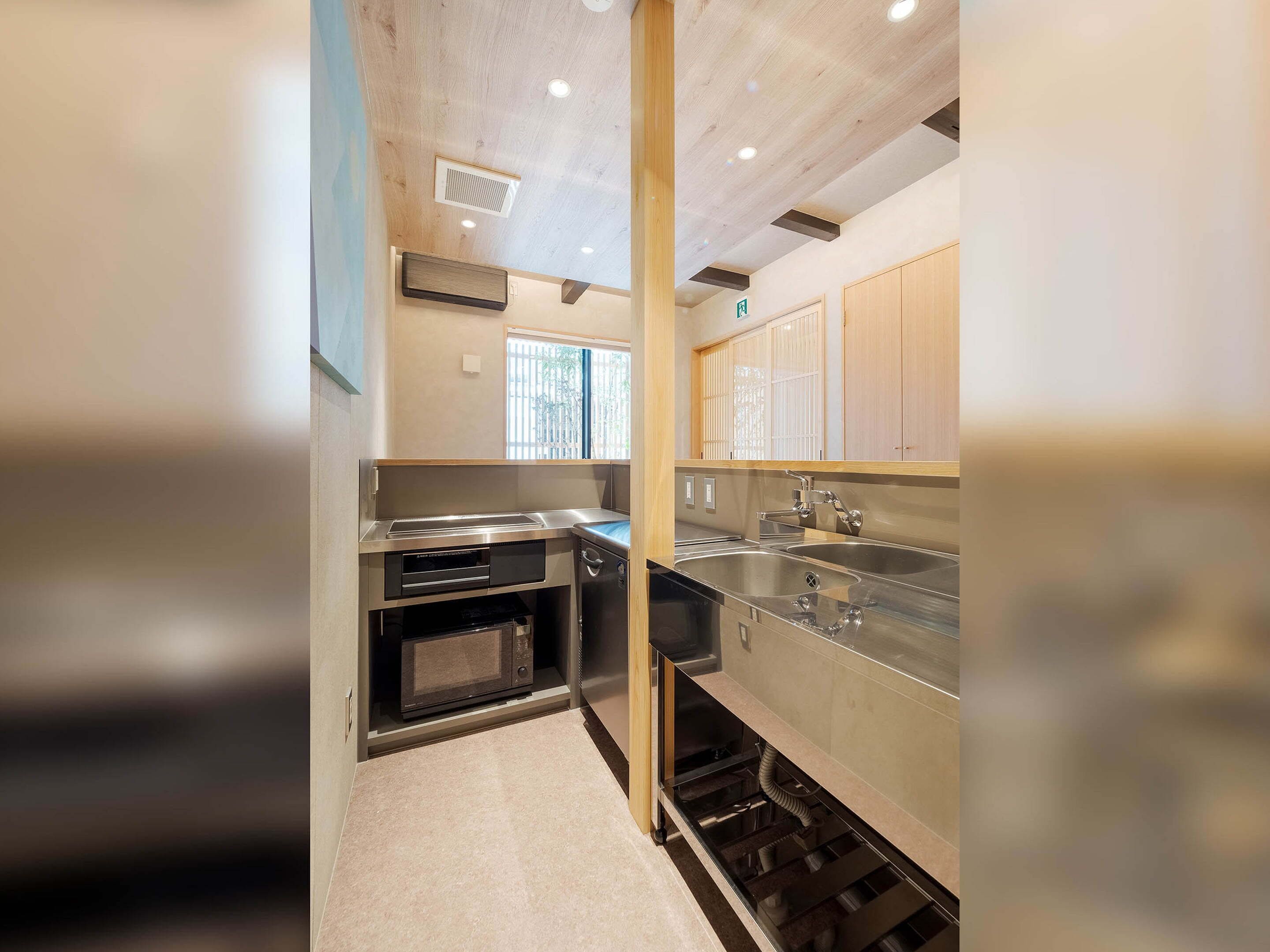 A compact kitchen with stainless steel appliances, a microwave, and a sink.