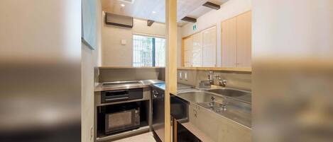 A compact kitchen with stainless steel appliances, a microwave, and a sink.