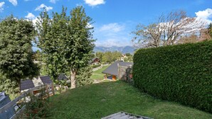 A residential area with a grassy slope, a wooden fence, and solar panels on rooftops. - Joli Appartement Proche du Centre (Nendaz)