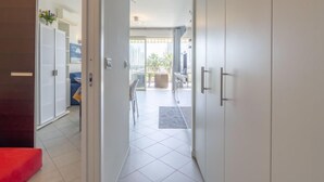 Ein Flur, der zu einem Balkon mit Blick ins Freie führt.