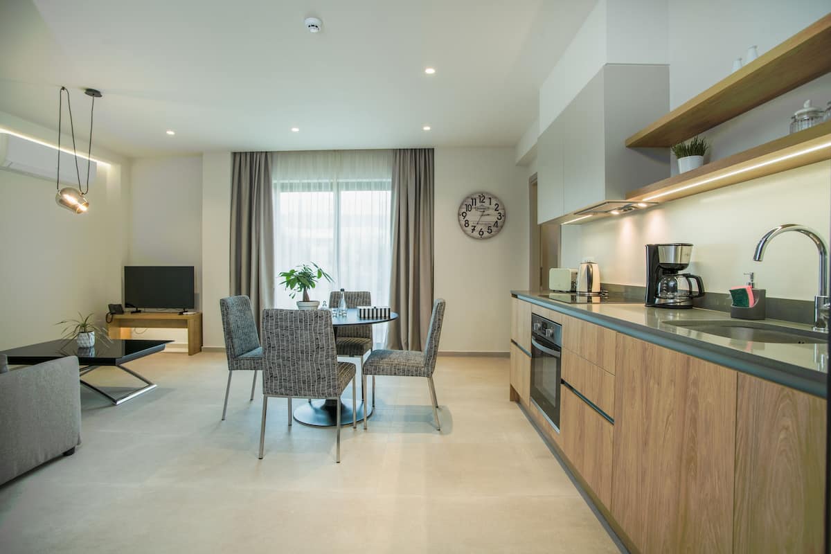 A modern kitchen with wooden cabinets, a built-in oven, and a coffee maker.