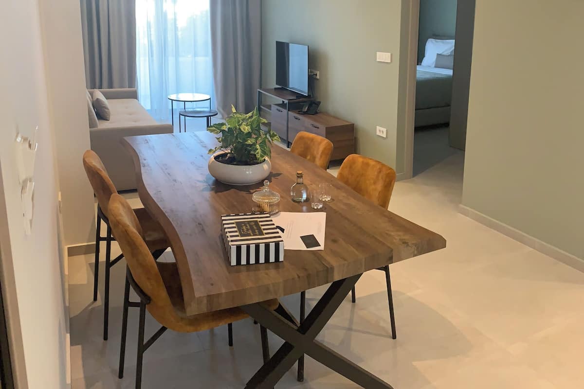 A modern dining area with a wooden table, chairs, and a potted plant.