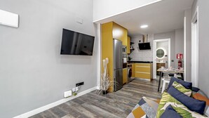 Eine moderne Küche mit Einbauofen, Mikrowelle und Kühlschrank. Ein Essbereich mit Tisch und Stühlen ist ebenfalls vorhanden.