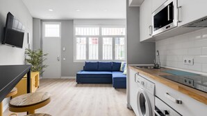 Une cuisine moderne équipée d’un four à micro-ondes, d’un lave-linge et d’un plan de travail en bois.