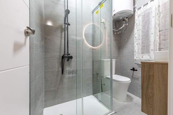 Een douche, een haardroger, handdoeken, toiletpapier