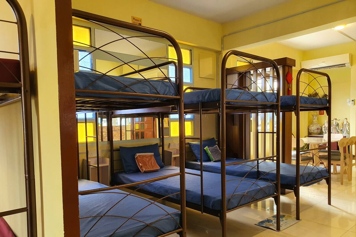 Un dormitorio con literas, una mesita pequeña y una silla.