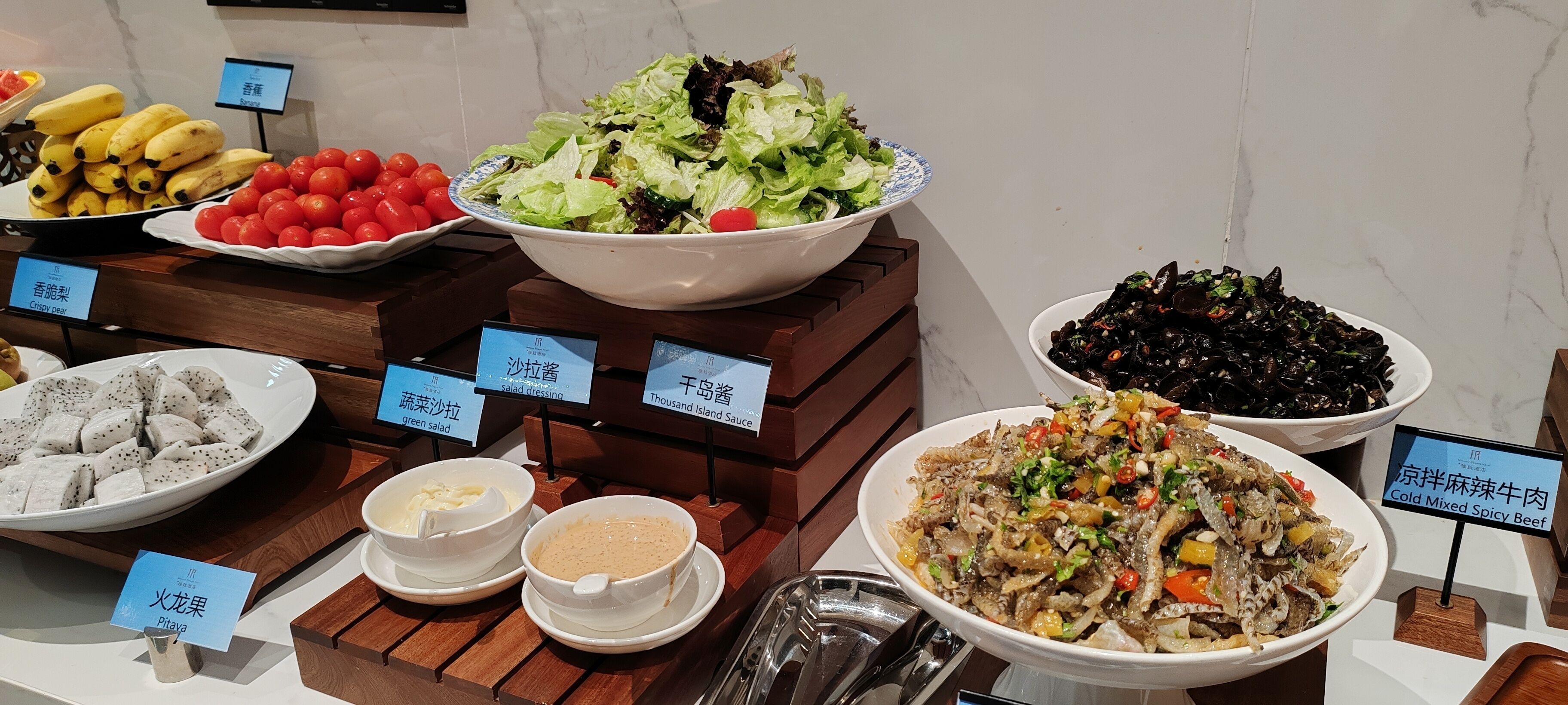 Un buffet proposant une variété de plats, notamment des salades, des fruits de mer et de la viande.