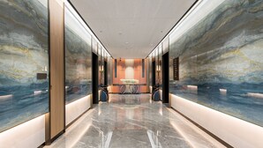 A modern elevator lobby with marble walls and a polished floor. - Mehood Elegant Hotel (Guangzhou Baiyun Airport T2 Terminal) (Guangzhou)