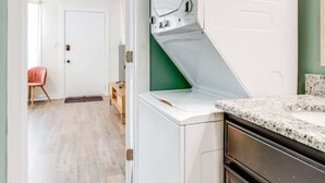 Una sala de lavandería con lavadora, secadora y una encimera.