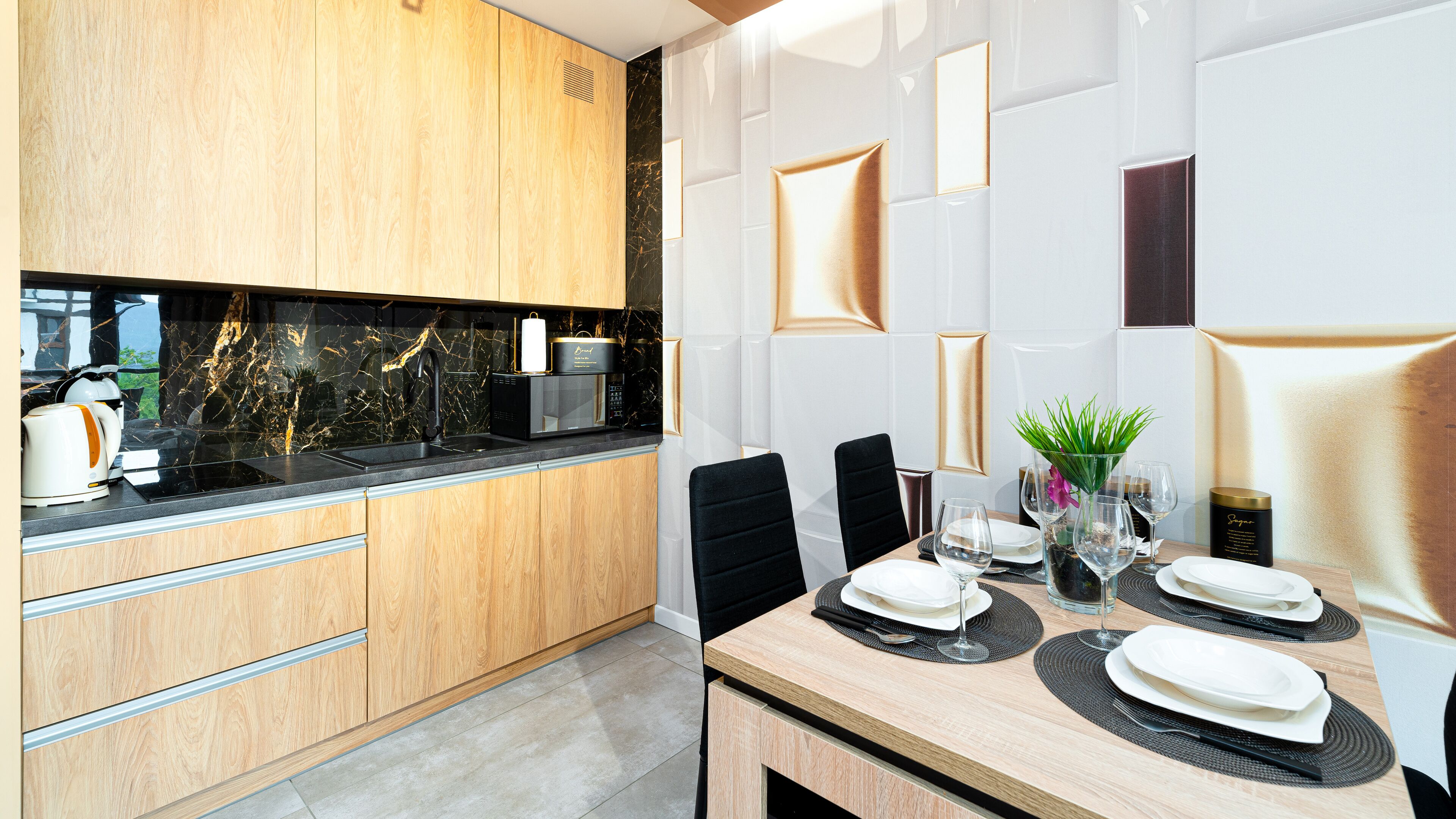 Eine moderne Küche mit Holzschränken, einer schwarzen Arbeitsplatte und einer Marmor-Spritzschutzwand.
