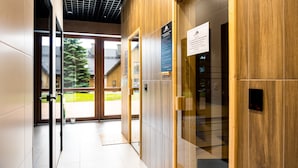 A modern elevator interior with wooden paneling and a digital display. - Apartamenty Sun & Snow Green Park (Szklarska Poreba)