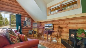 A cozy cabin interior with a wooden interior, a fireplace, a television, and a sign welcoming visitors to Bear Hollow. - Carnelian Lodge Log Cabin, Sleeps 9, Hot Tub (Carnelian Bay)