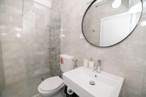 A modern bathroom with a toilet, sink, and shower. - The Rooftop Apartment with Sea view (Ulcinj)