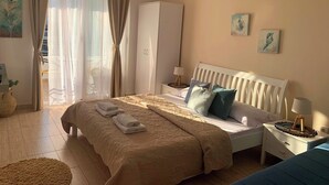 Ett hotellrum med en säng, sängbord, en garderob och konstverk på väggarna.