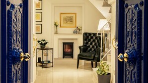 A grand entrance with a chandelier, a fireplace, and a black armchair. - Room in Guest Room - "the 10 Square" - A Townhouse Situated in the Heart of Siggiewi Village Square (Siggiewi)