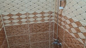 A bathroom with a toilet, a shower, and a window. - Nabateans Home Hotel (Wadi Musa)