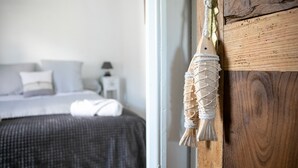 Ein Schlafzimmer mit einem Bett, einem Nachttisch und einer Holzwand mit einer Seildekoration.
