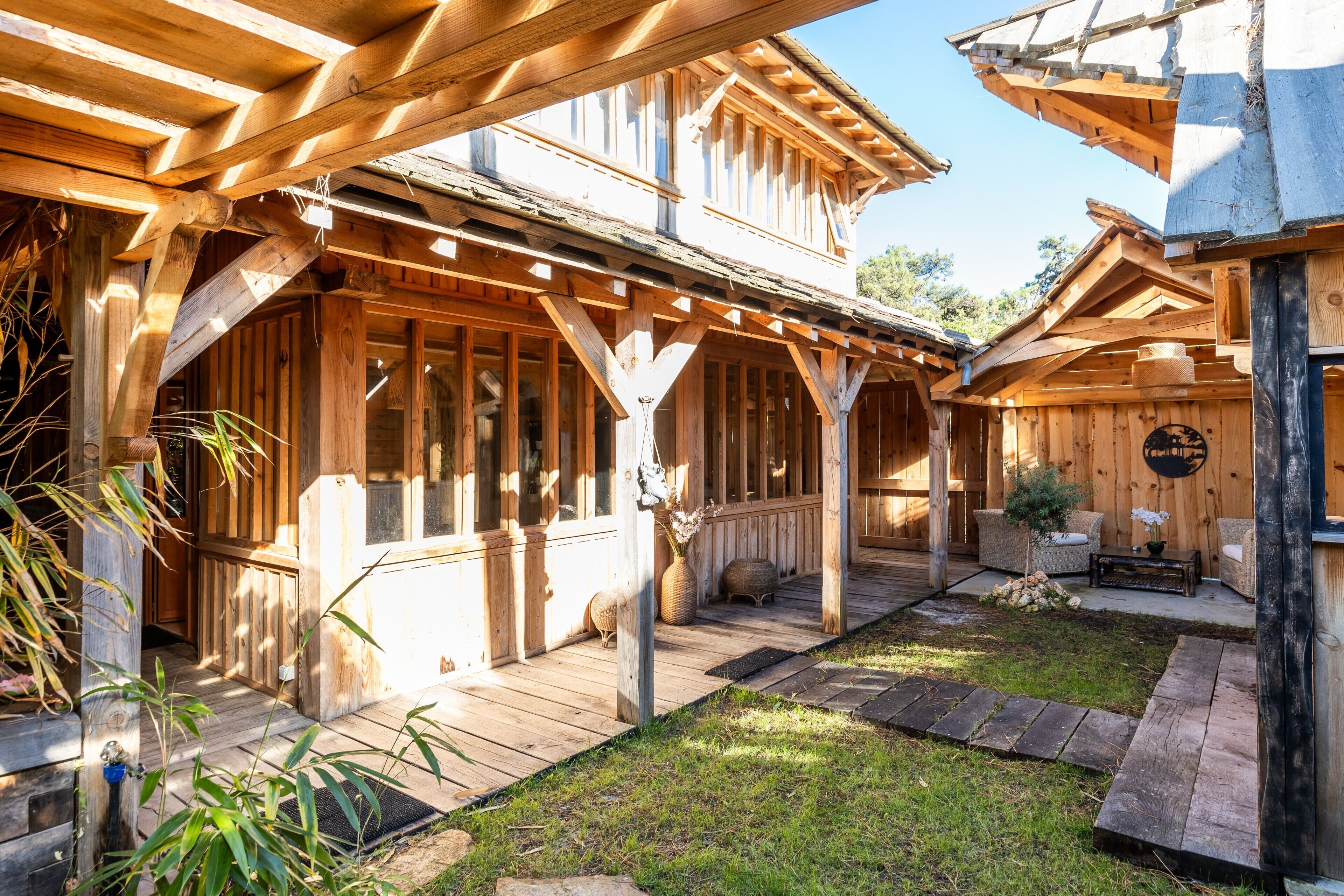 A wooden cabin with a porch, a small garden, and a stone pathway.