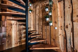 A wooden interior with a staircase, wooden shelves, and hanging planters. - Villa "Chan-Ly Été" with Private Terrace, Private Hot Tub, and Wi-Fi (Lacanau)