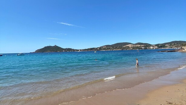 A beach with clear blue water, a sandy shore, and distant hills. - Petite Villa Attrayante vue mer Avec Jardin et Parking Privé (Saint-Raphaël)