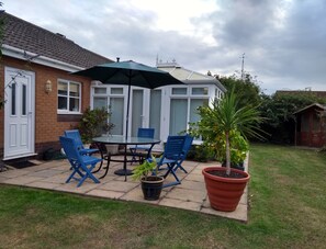 Enjoy dining or socializing in this patio area with a glass table and four chairs.