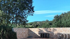 A clear swimming pool with stone walls and a view of the surrounding greenery. - Villa "Norgreen 4" with Private Pool, Private Terraces and Wi-Fi (Grimaud)