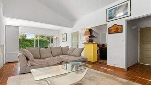A living room with a glass coffee table, beige sofa, and a yellow cabinet. - Villa "Norgreen 4" with Private Pool, Private Terraces and Wi-Fi (Grimaud)
