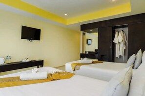 A hotel room with two beds, a flat-screen TV mounted on the wall, a desk with a chair, and a mirror reflecting the room. - Stay Resort Pattaya (Pattaya)