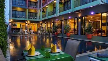 Alberca al aire libre, sombrillas en la alberca y camastros