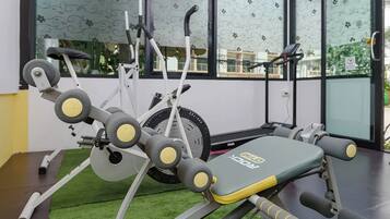 Un gimnasio con varios equipos de ejercicio, incluyendo una banca y una cinta de correr.